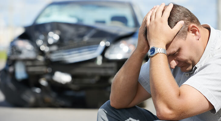 Vanishing deductible: stressed man near a damaged car