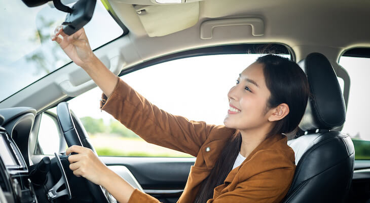 Hartford TrueLane: woman adjusting her car's rear-view mirror