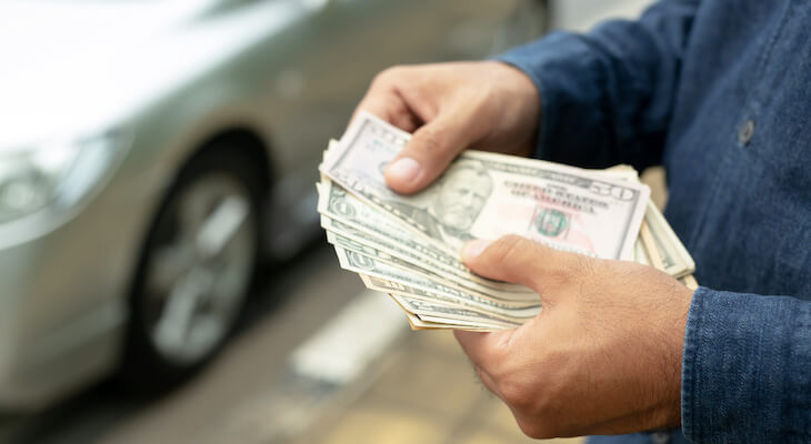 Kemper auto insurance: person holding bills