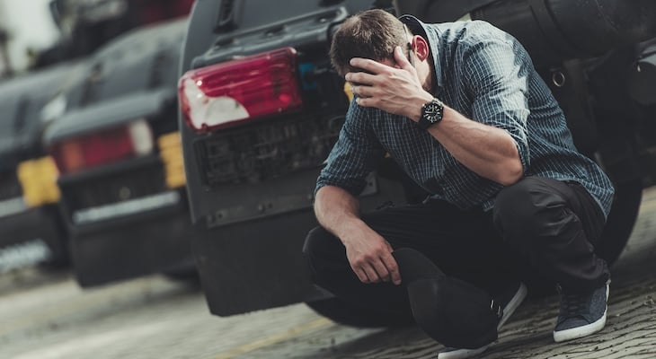 Man crouched down by car worrying about how much a DUI costs