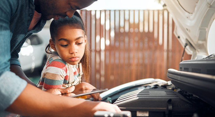 father and daughter working on a car
