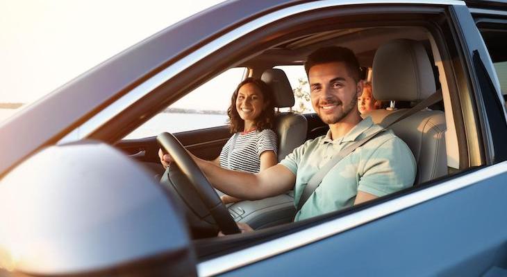 Liability car insurance: happy couple inside their car