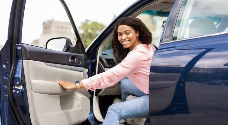 SMiling woman getting into her car after getting on the Georgia Automobile Insurance Plan