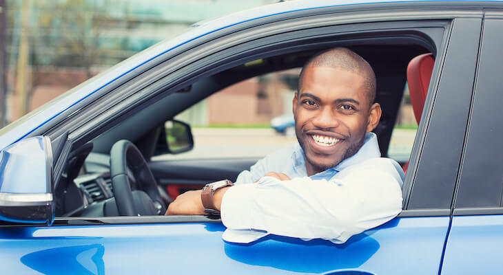The General car insurance reviews: man smiling while sitting in his car
