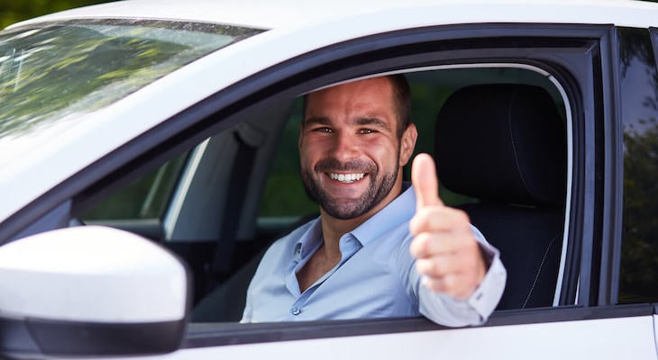Man giving us the thumbs-up while sitting in his car