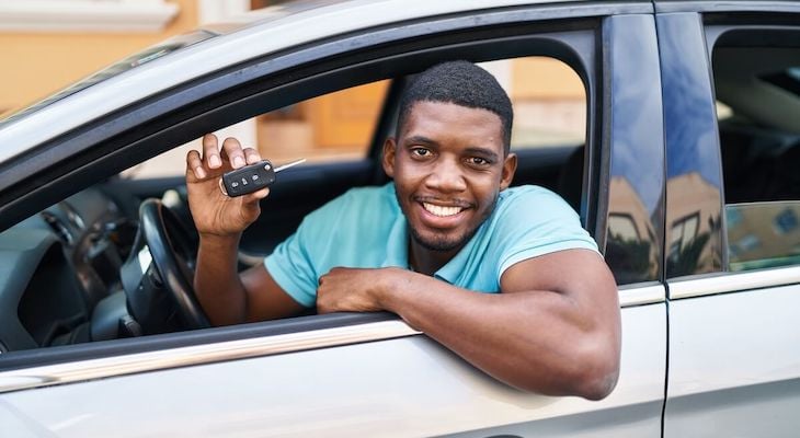When to buy car insurance: man happily holding a car key