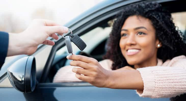 Insurance to rent out your car: person handing a car key to a woman