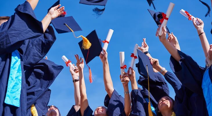 Does education level affect car insurance: graduates throwing their mortarboards up in the air