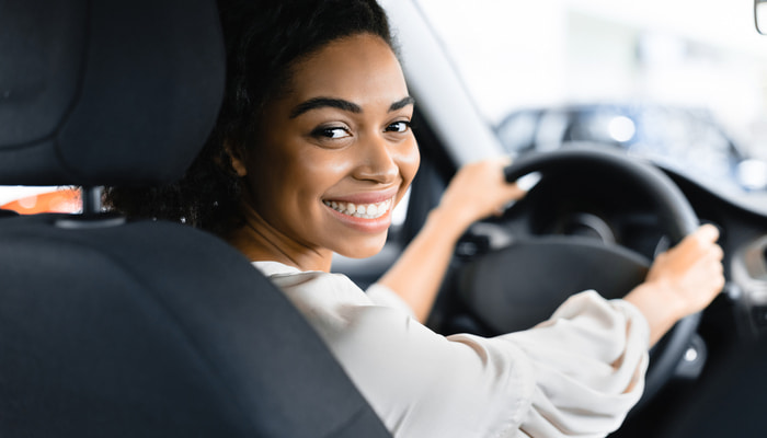 young woman smiling while driving in car 