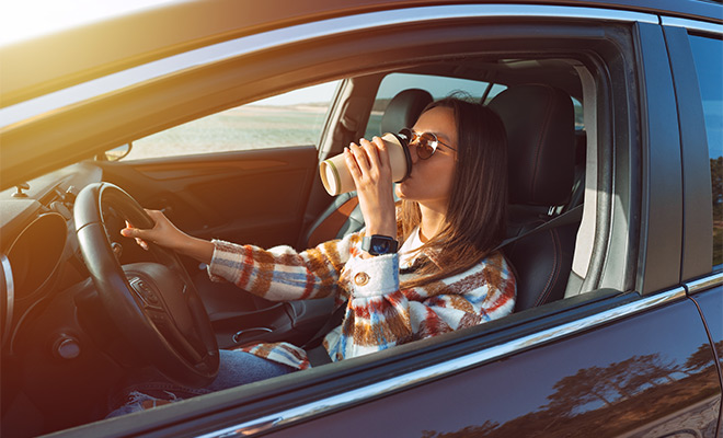 woman drinking coffee in car