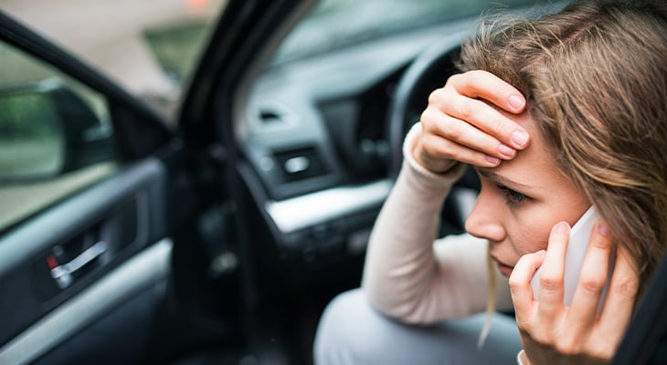Worried woman on the phone inside a car