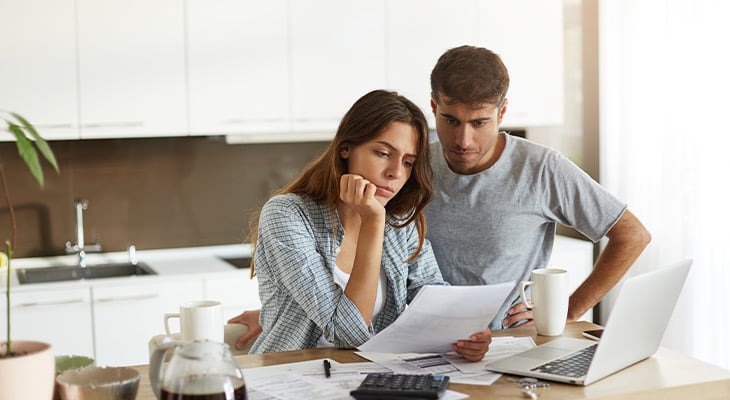 Young stressed couple looks at papers