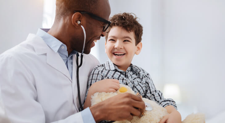 Doctor holds smiling child