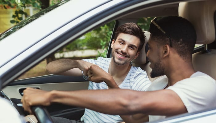 Friends in car talking about how to find cheap car insurance