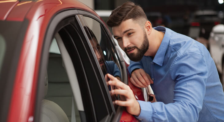Man examining a car in a showroom