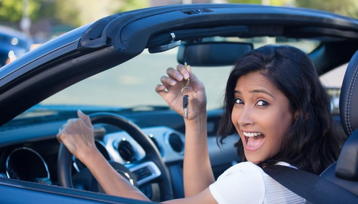 Young woman in car who learned how to insure a car she doesn't own