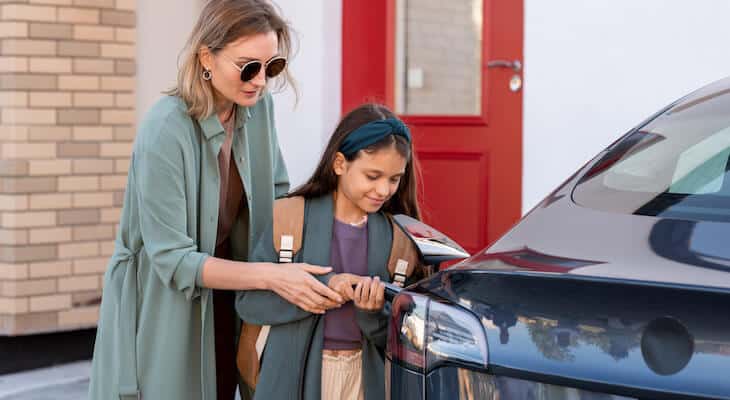 How much does supercharging cost: mother and daughter charging their electric car