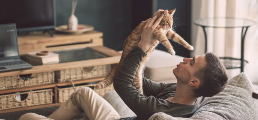 Man holding his cat at home 