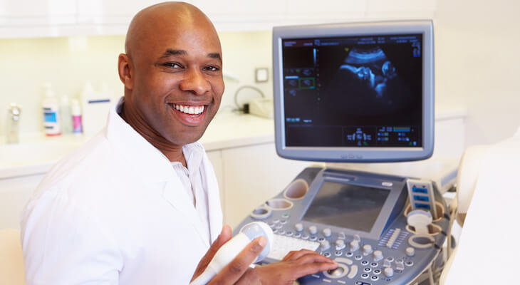 How much is an ultrasound without insurance: smiling doctor operating a 4D ultrasound