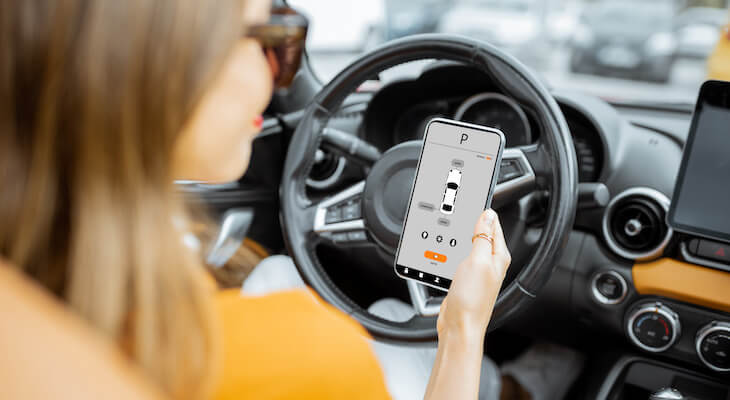 Woman controlling her car using a mobile app