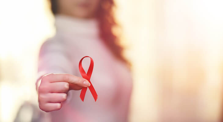 How much does an STD test cost: woman holding a red ribbon