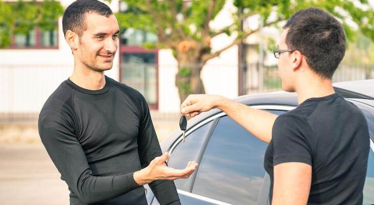 Tesla trade in: man handing his car keys to another man