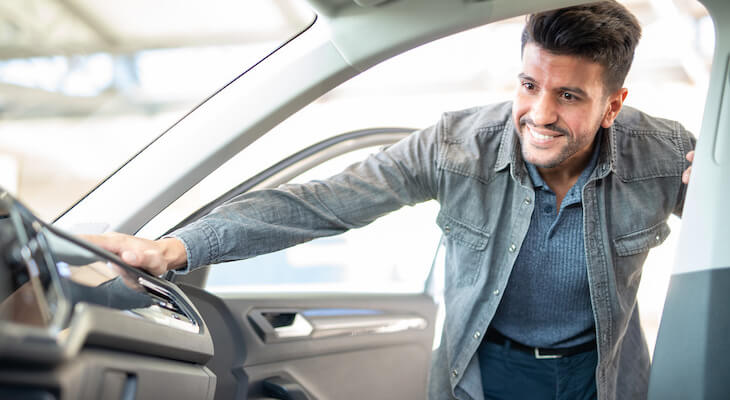Salvage title: man looking at the interior of a car