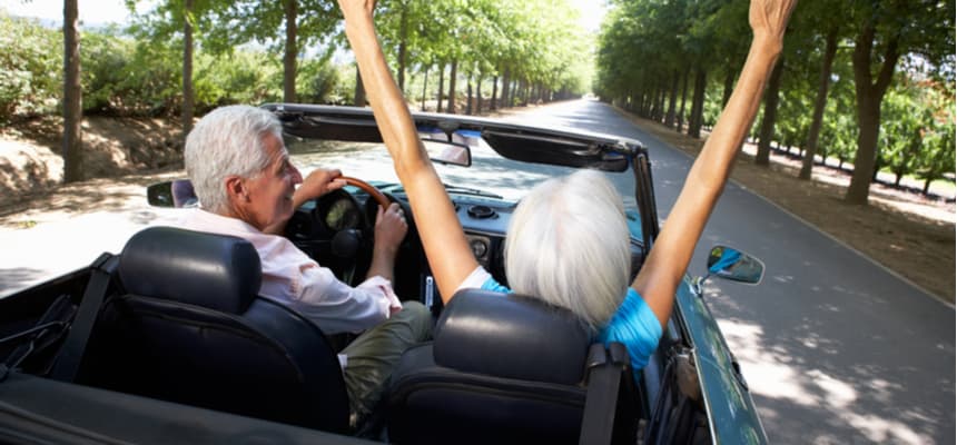 retired couple enjoying a ride in convertible