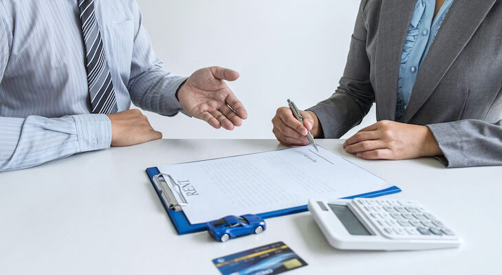 New car insurance grace period: agent showing a client where to sign