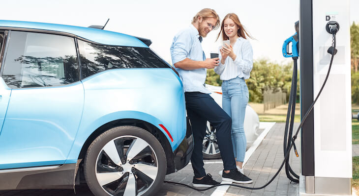 Couple charging their car at a charging station