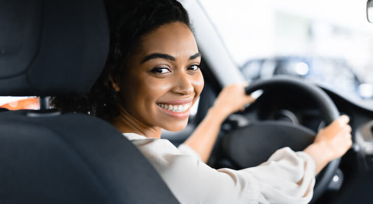 New driver car insurance: woman in the driver seat looking behind her