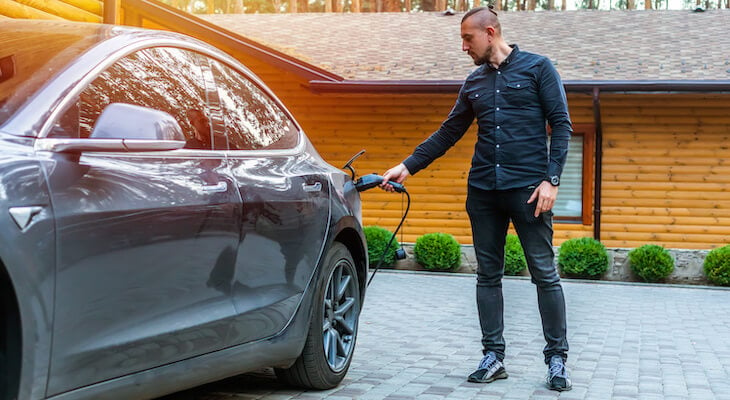 Tesla 6 seater: man charging his electric car