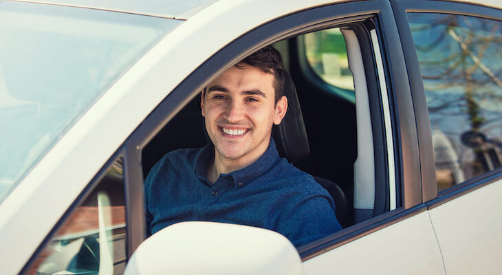 New driver car insurance: man in his car, smiling