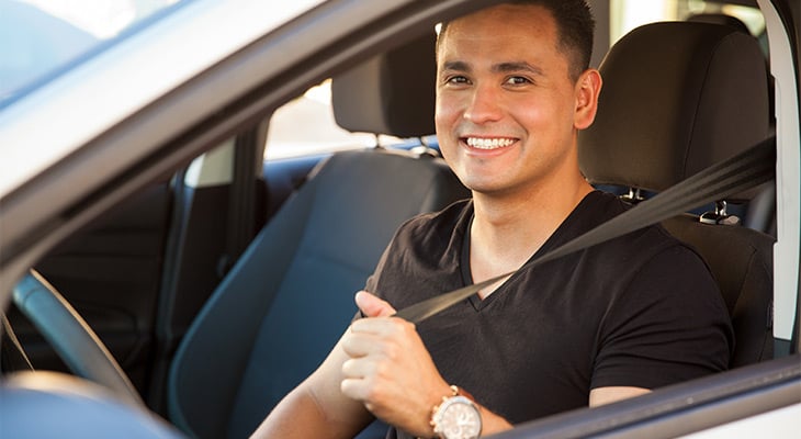 Man in black shirt looking out car window smiling