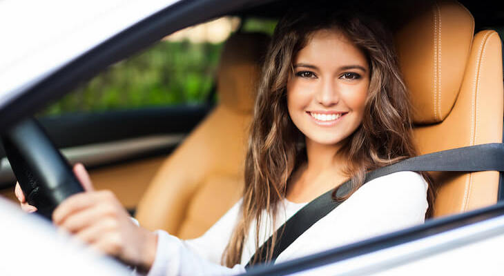 Woman in the driver seat, smiling to the camera