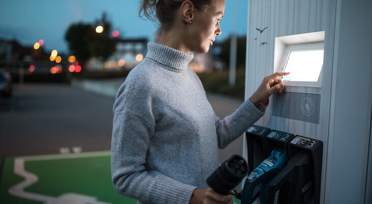 Level 1 vs level 2 charging: woman holding an EV charger
