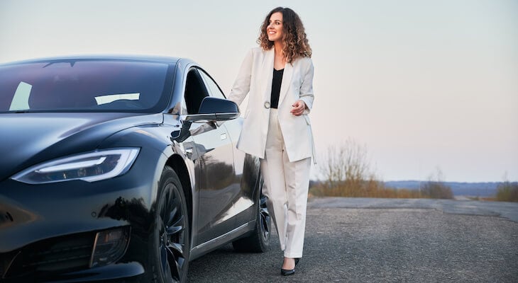 Tesla depreciation: woman standing beside her car