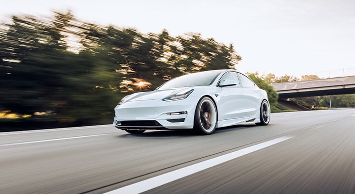 Full shot of a white Tesla car on the road