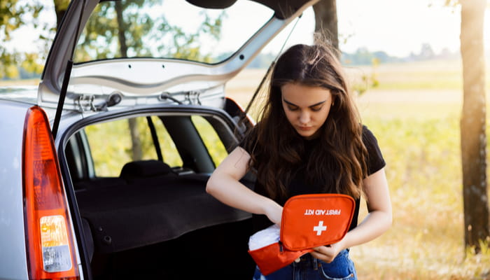 woman looking in first aid kit in her car