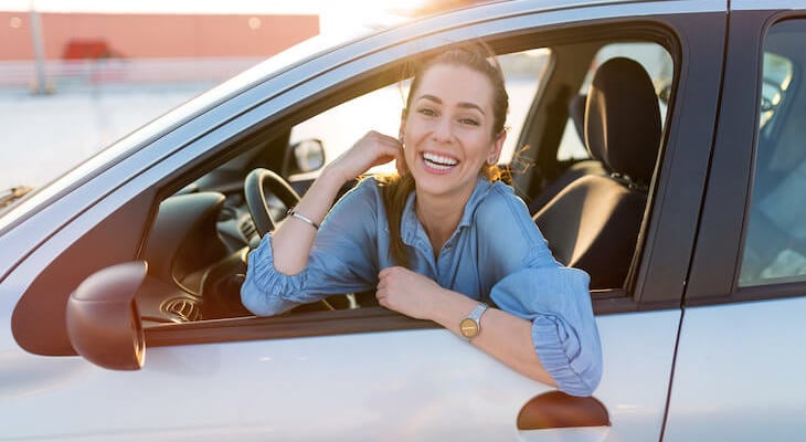 Happy woman inside her car