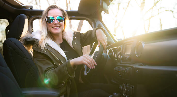 Woman happily sitting inside a car