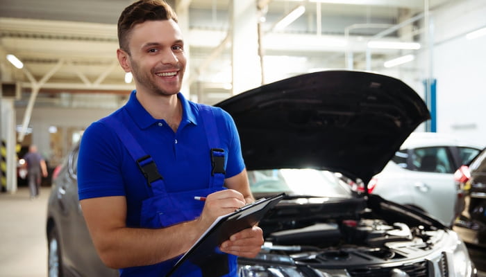 man fixing a vehicle with a mechanical breakdown insurance plan
