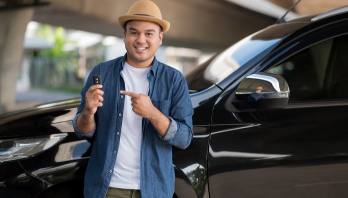 man holding his car key after getting a car loan