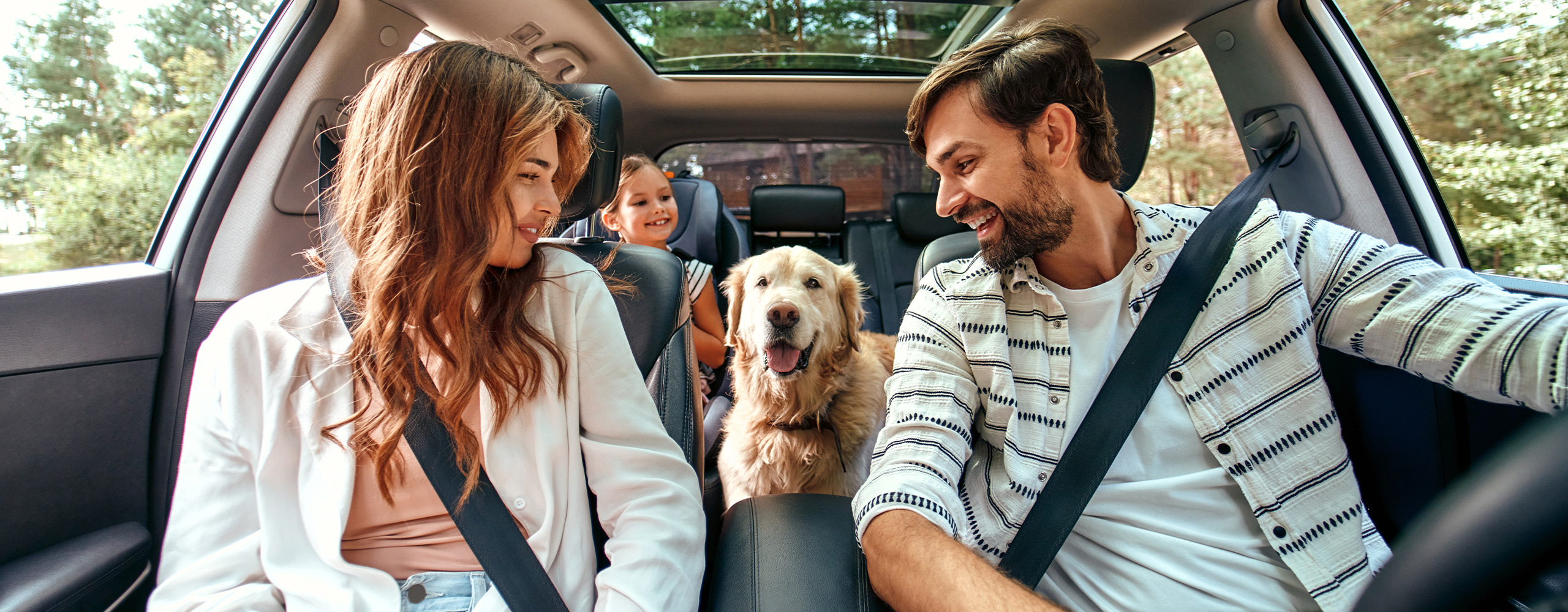 family and dog in a car