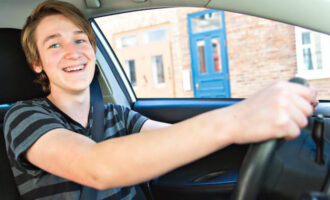 Young driver smiling behind the wheel
