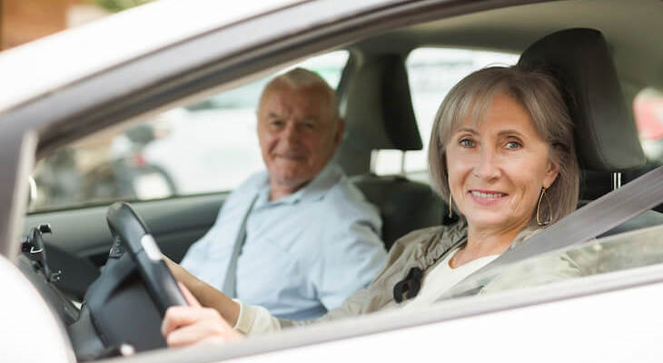 Auto insurance for seniors: senior couple riding a car