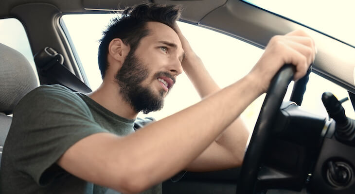 Car insurance for bad drivers: stressed man driving a car
