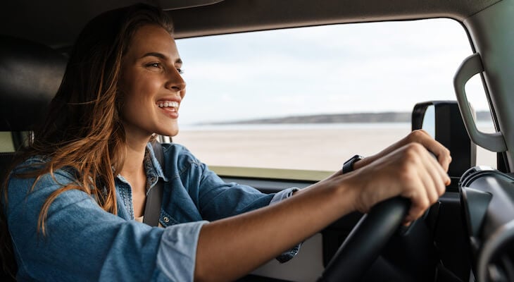 Best car insurance for young drivers: woman happily driving a car