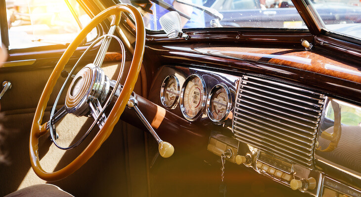 The steering wheel and dashboard interior of a classic car