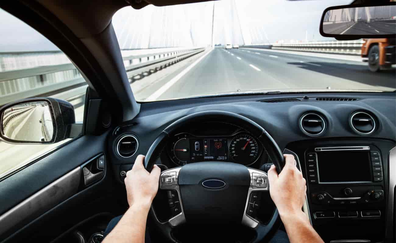 hands holding steering while while driving car
